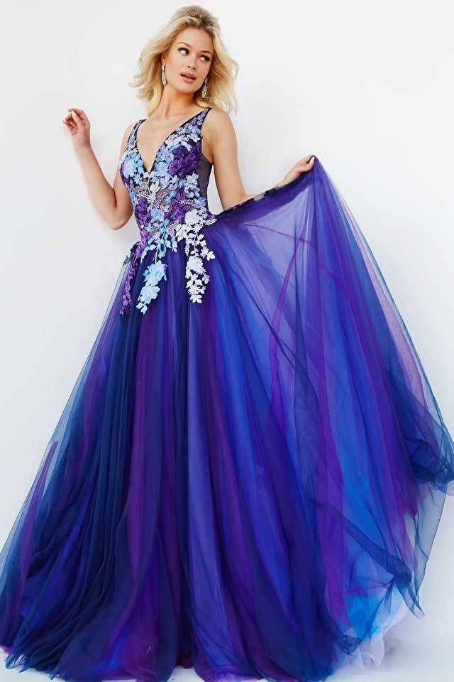 A woman poses against a plain white background wearing the Long Prom Dress 06807 by Jovani, featuring a tulle navy ball gown design with a V-neckline, floral bodice detailing, and a blue and purple floor-length skirt.